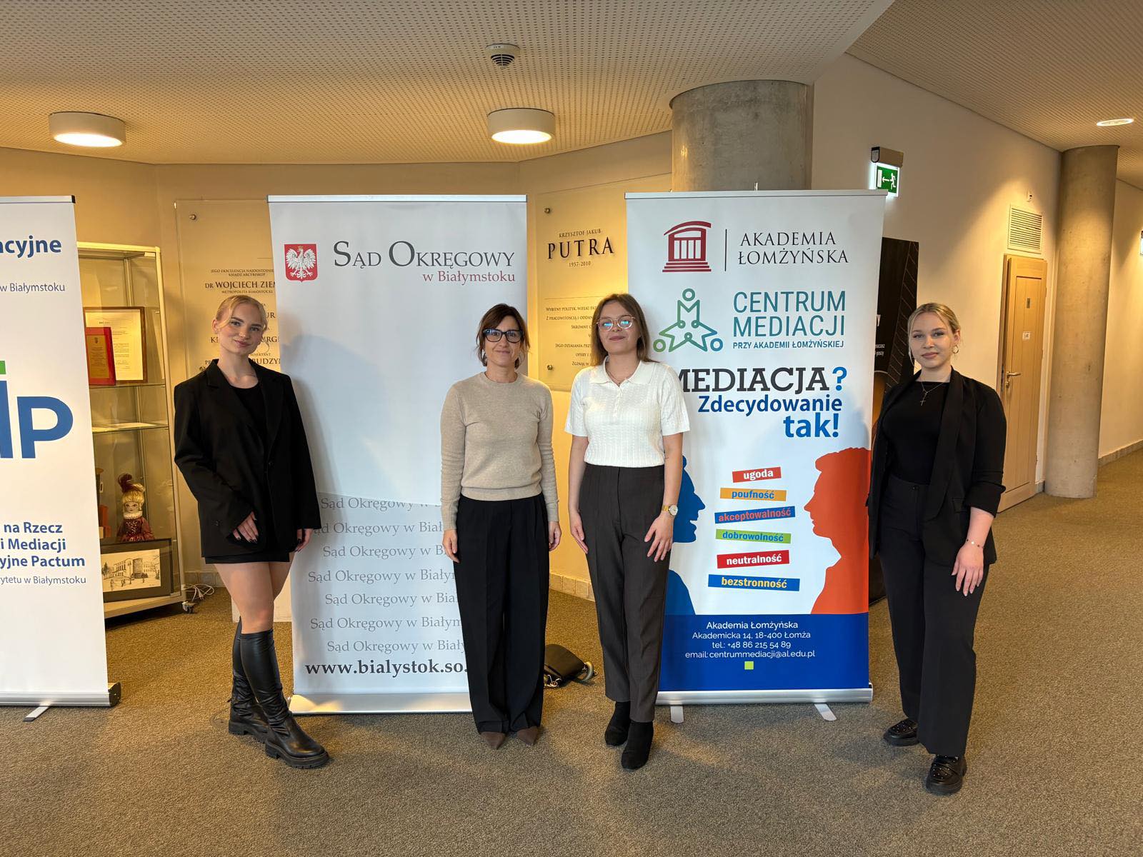 kilka osób na tle ścianki reklamowej