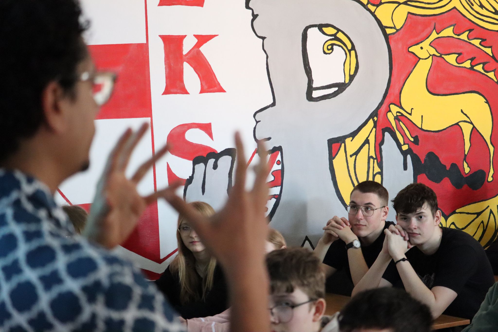 Wykładowca mówi do grupy uczniów zgromadzonych w sali