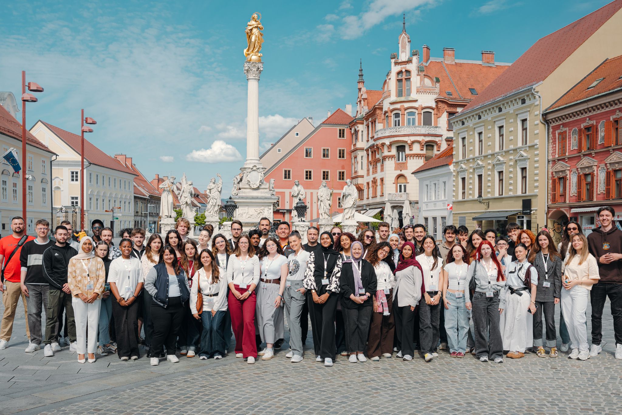 Grupa studentów pozuje na tle starego rynku w Mairborze