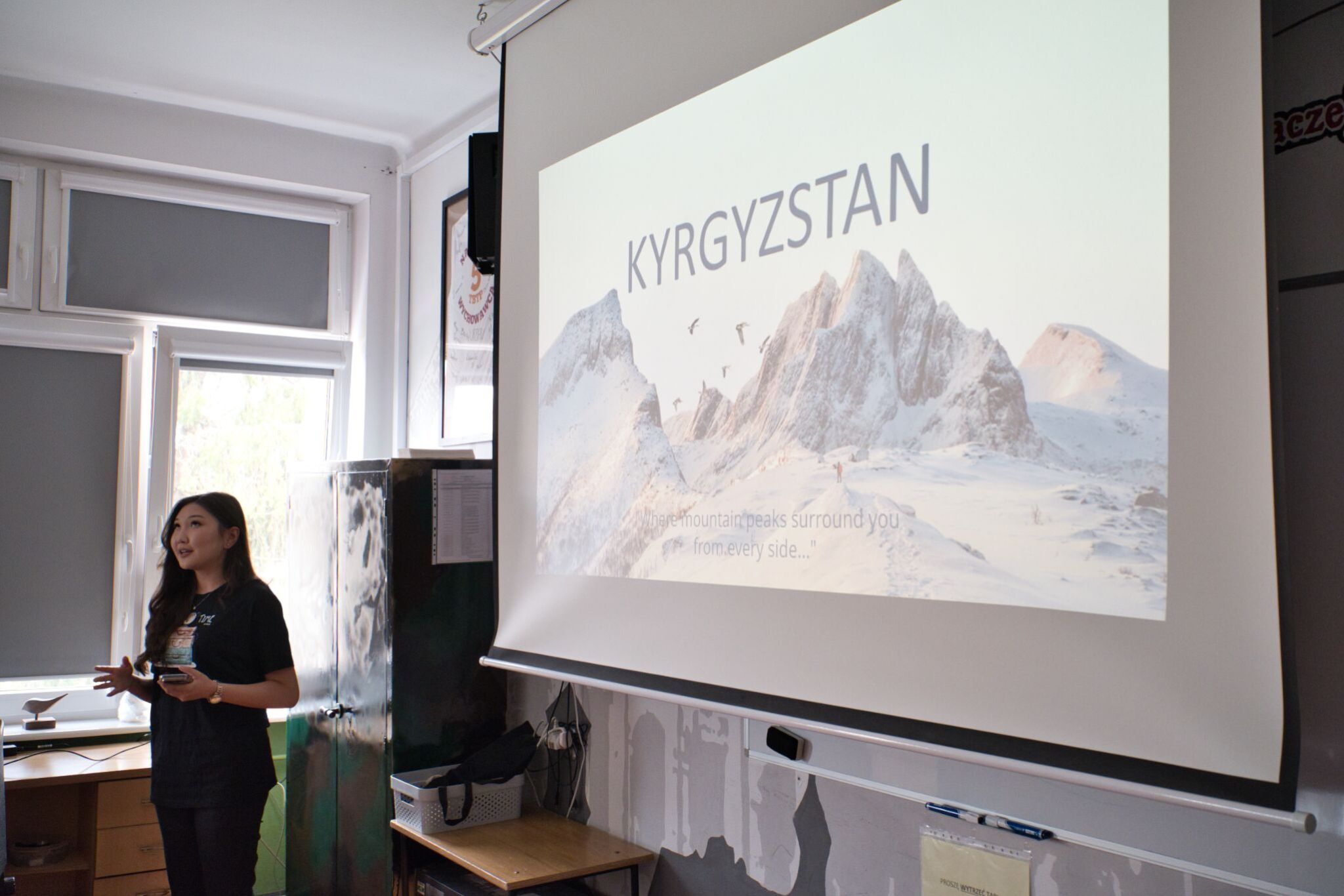 Studentka na tle prezentacji mówi do osób będących poza kadrem