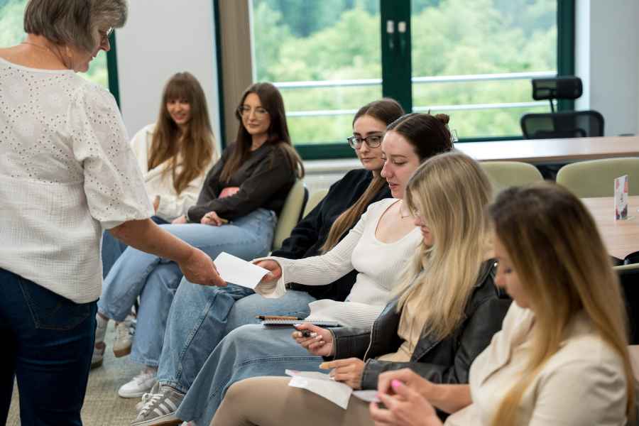 studenci siedzą na krzesłach w sali warsztatowej