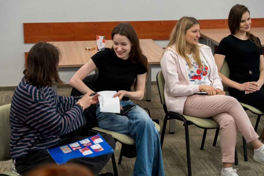 studenci siedzą na krzesłach w sali warsztatowej