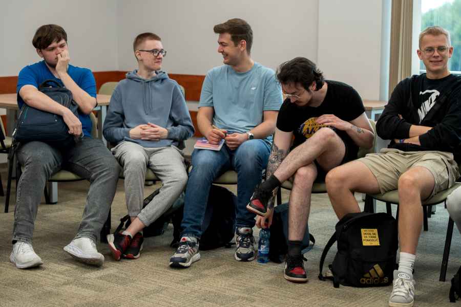 studenci siedzą na krzesłach w sali warsztatowej