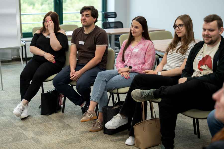 studenci siedzą na krzesłach w sali warsztatowej