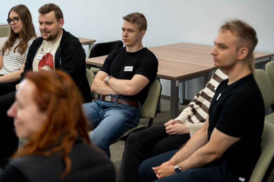 studenci siedzą na krzesłach w sali warsztatowej