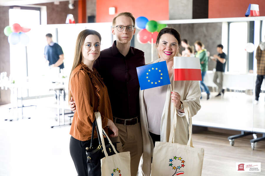 Grupa trzech osób, trzymają w rękach flagę Unii Europejskiej oraz Polski
