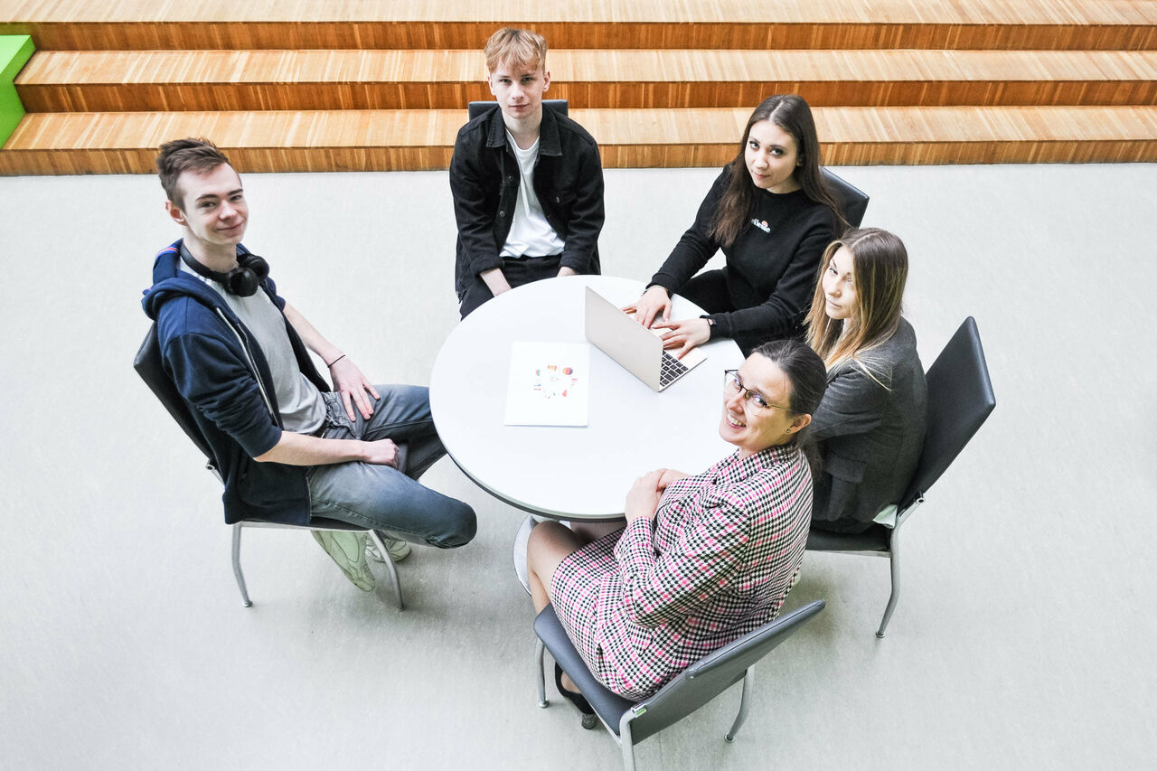 Management Students sitting by the oval table in the Foyer