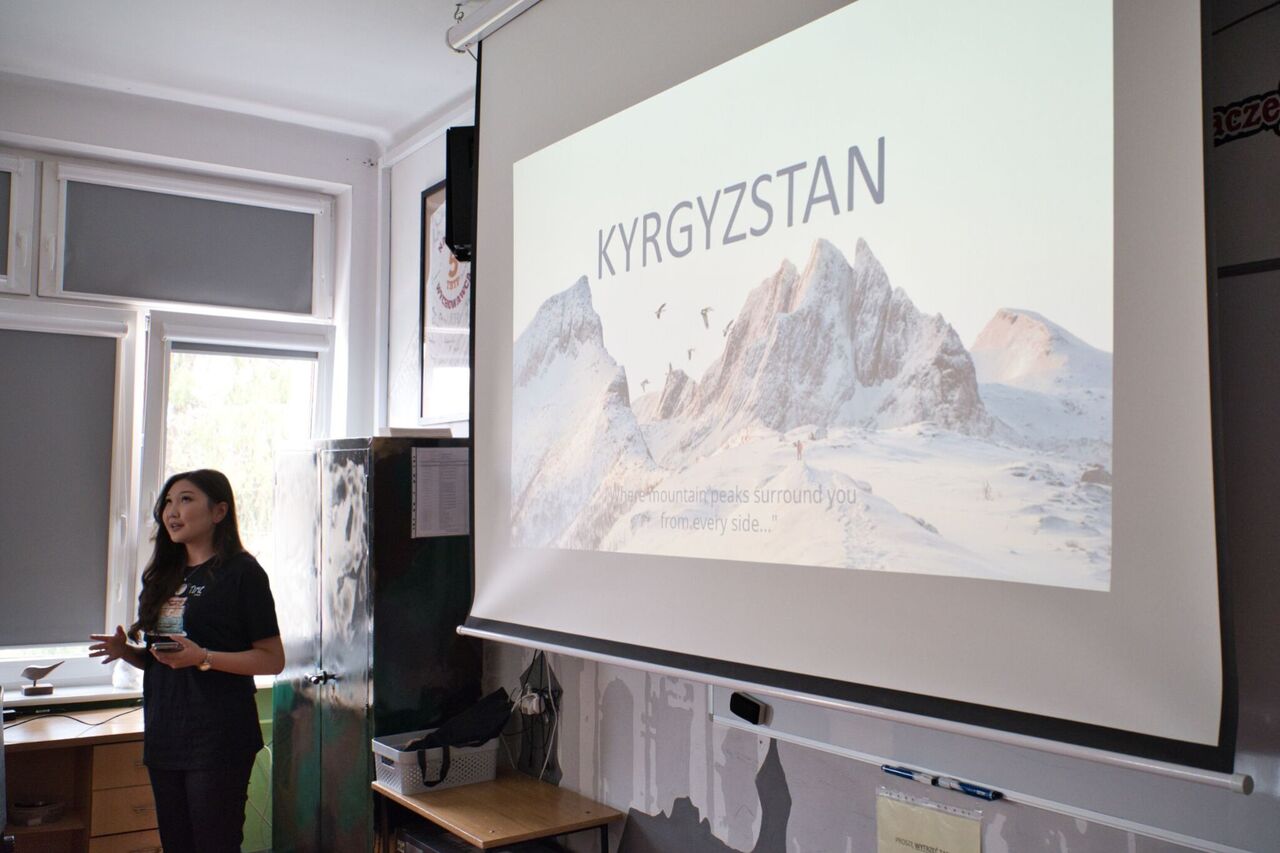 Studentka na tle prezentacji mówi do osób będących poza kadrem