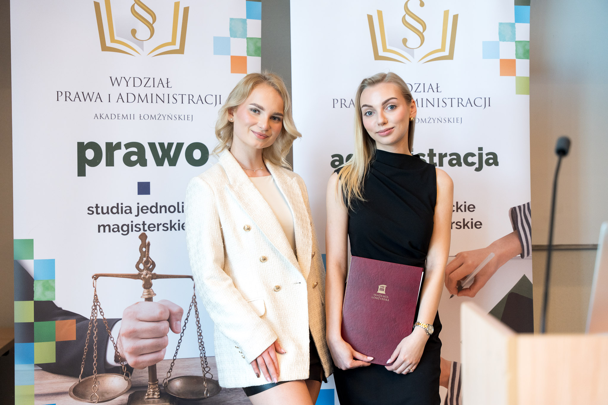 grupa osób pozuje do zdjęcia na scenie auli
