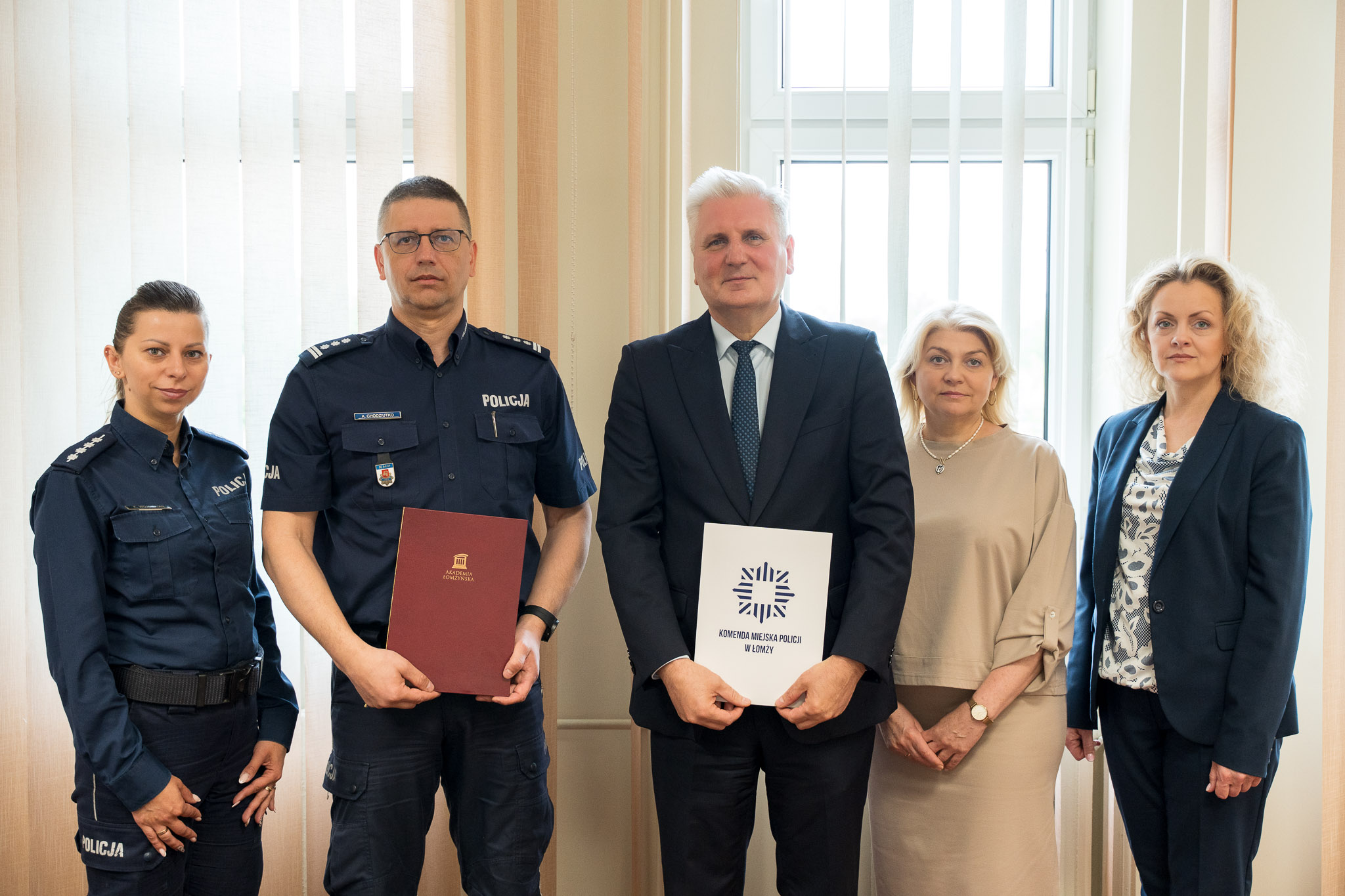 pięć osób pozuje do zdjęcia