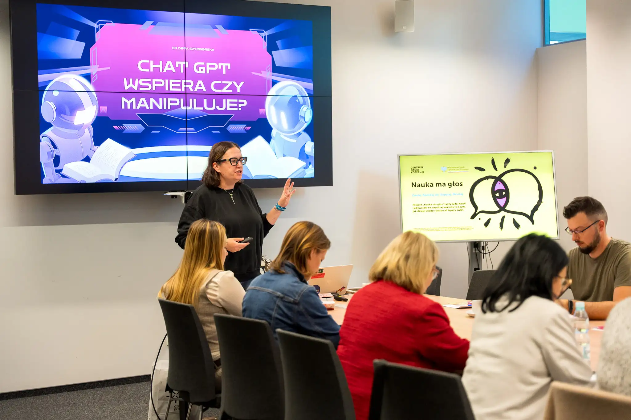 na zdjęciu widać 5 osób, z czego jedna przedstawia prezentację