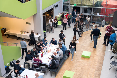 ludzie zgromadzeni na forum w budynku uczelni