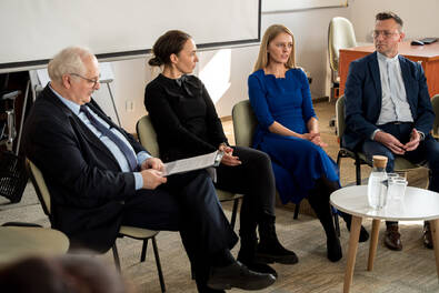 Grupa osób siedzi w półokręgu podczas spotkania lub dyskusji panelowej w sali konferencyjnej.” Jeśli chcesz, mogę przygotować także wersję rozszerzoną lub kilka wariantów do różnych zastosowań WCAG