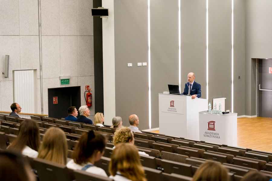 Mężczyzna przemawiający z mównicy do grupy osób