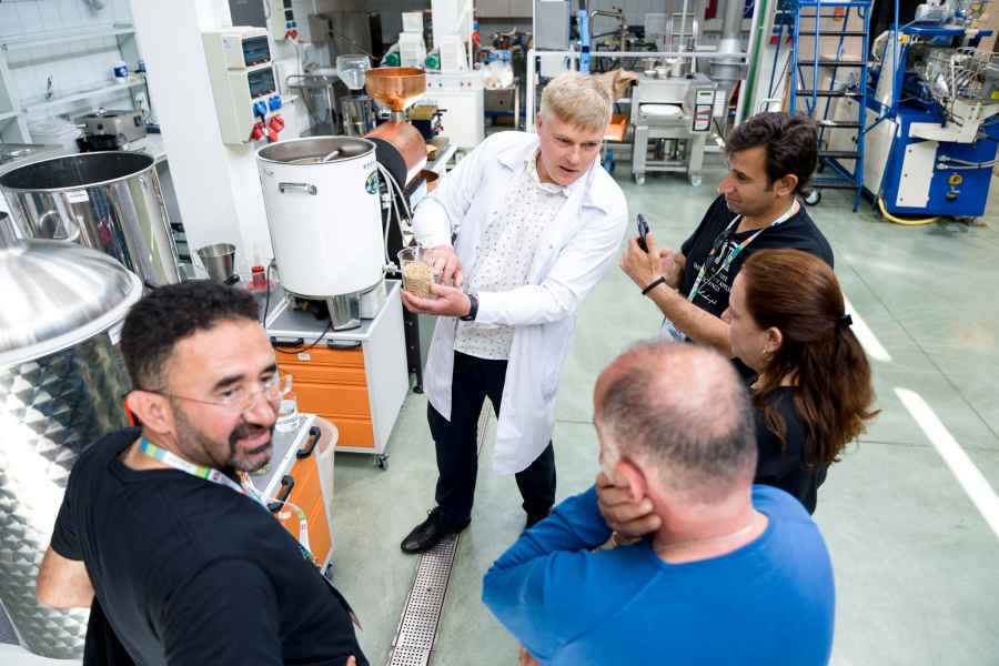 Grupa osób zwiedzająca halę technologiczną