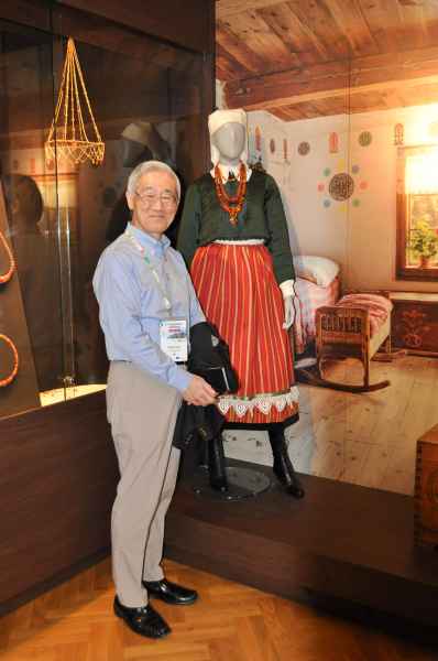 Mężczyzna stojący przy stroju ludowym w muzeum