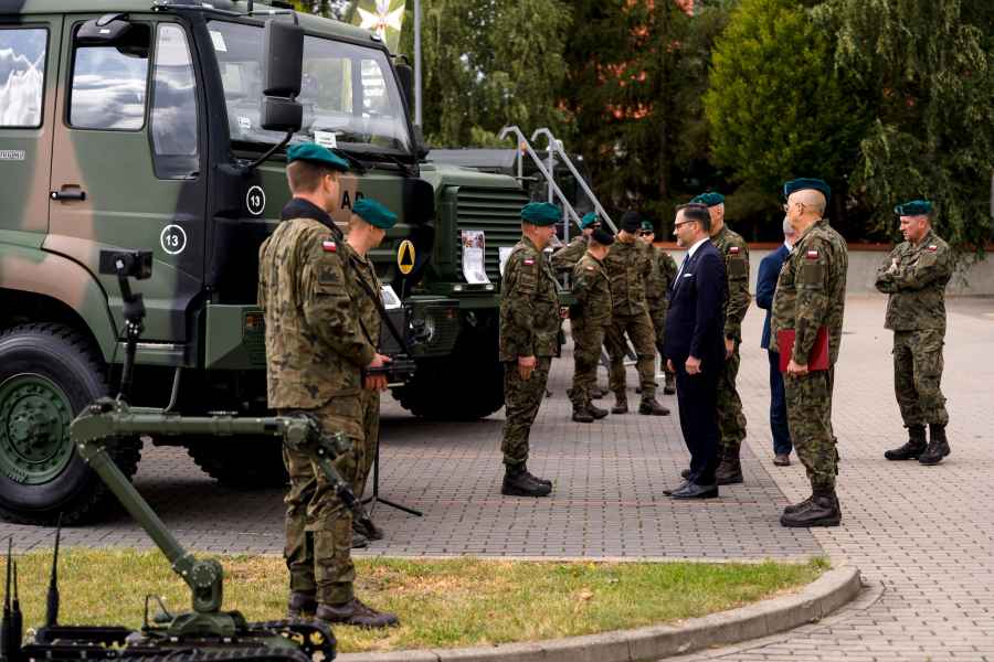 Żołnierze stojący przy samochodach wojskowych