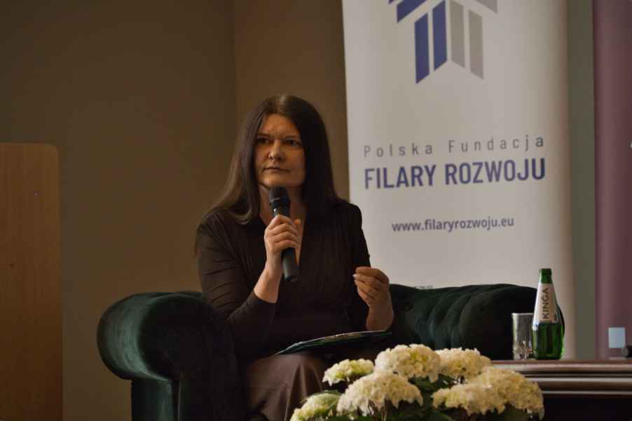 Uczestnik konferencji trzymajacy w dłoni mikrofon