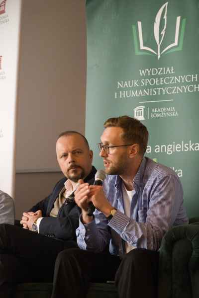 Uczestnik konferencji trzymający mikrofon w dłoni