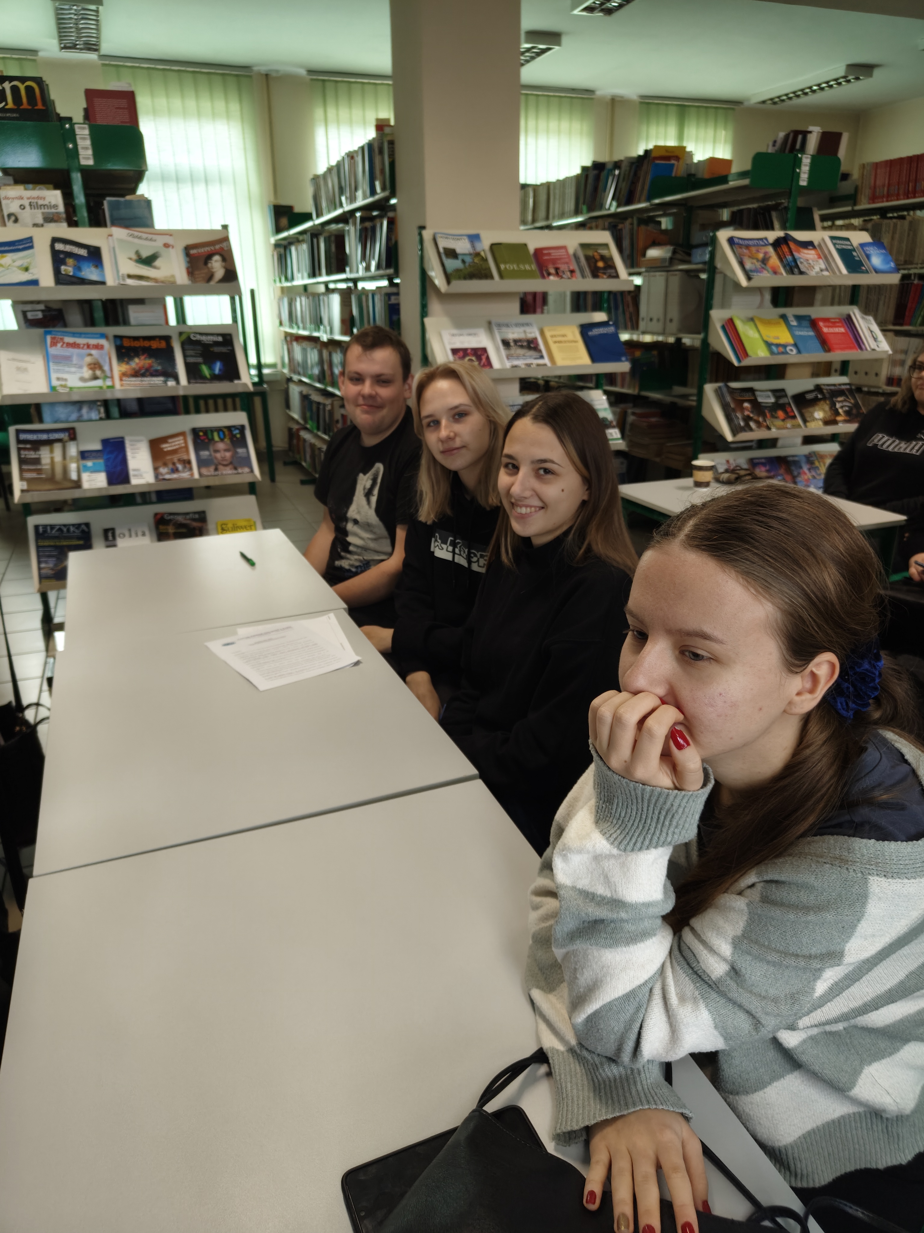 Studenci w bibliotece wysłuchują wykładu