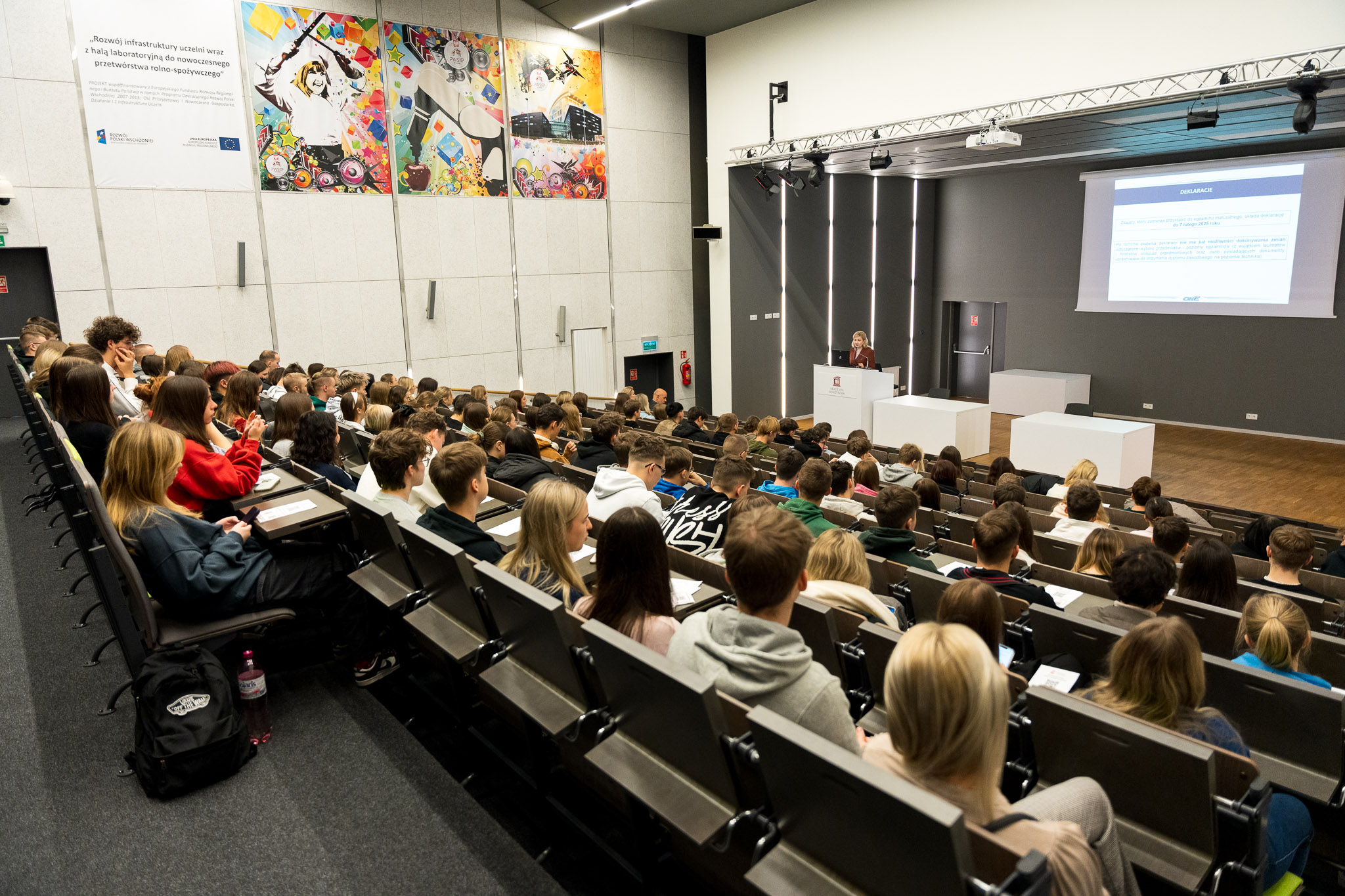 aula pełna ludzi na scenie wykładowca