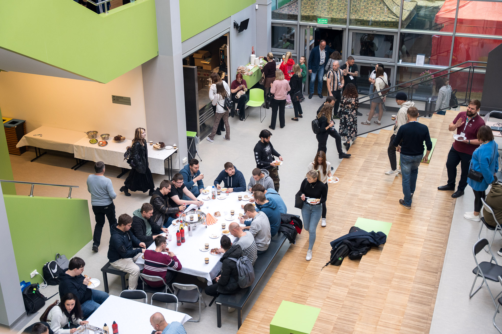 ludzie zgromadzeni na forum w budynku uczelni