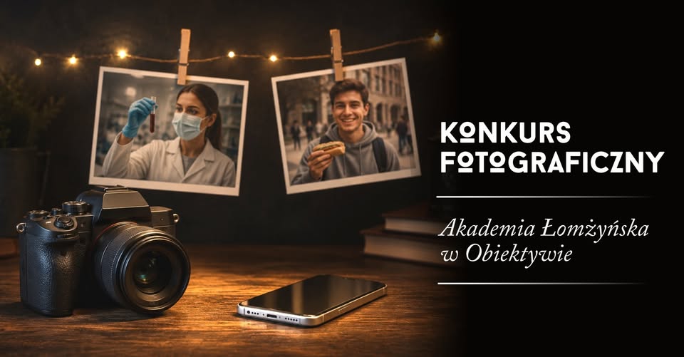 Grafika promocyjna utrzymana w ciepłej, przyciemnionej kolorystyce. Na pierwszym planie, po lewej stronie, znajduje się aparat fotograficzny ustawiony na drewnianym blacie. Obok aparatu leży smartfon ekranem skierowanym do góry. Po prawej stronie grafiki znajduje się tekst: „KONKURS FOTOGRAFICZNY” oraz poniżej „Akademia Łomżyńska w Obiektywie”.