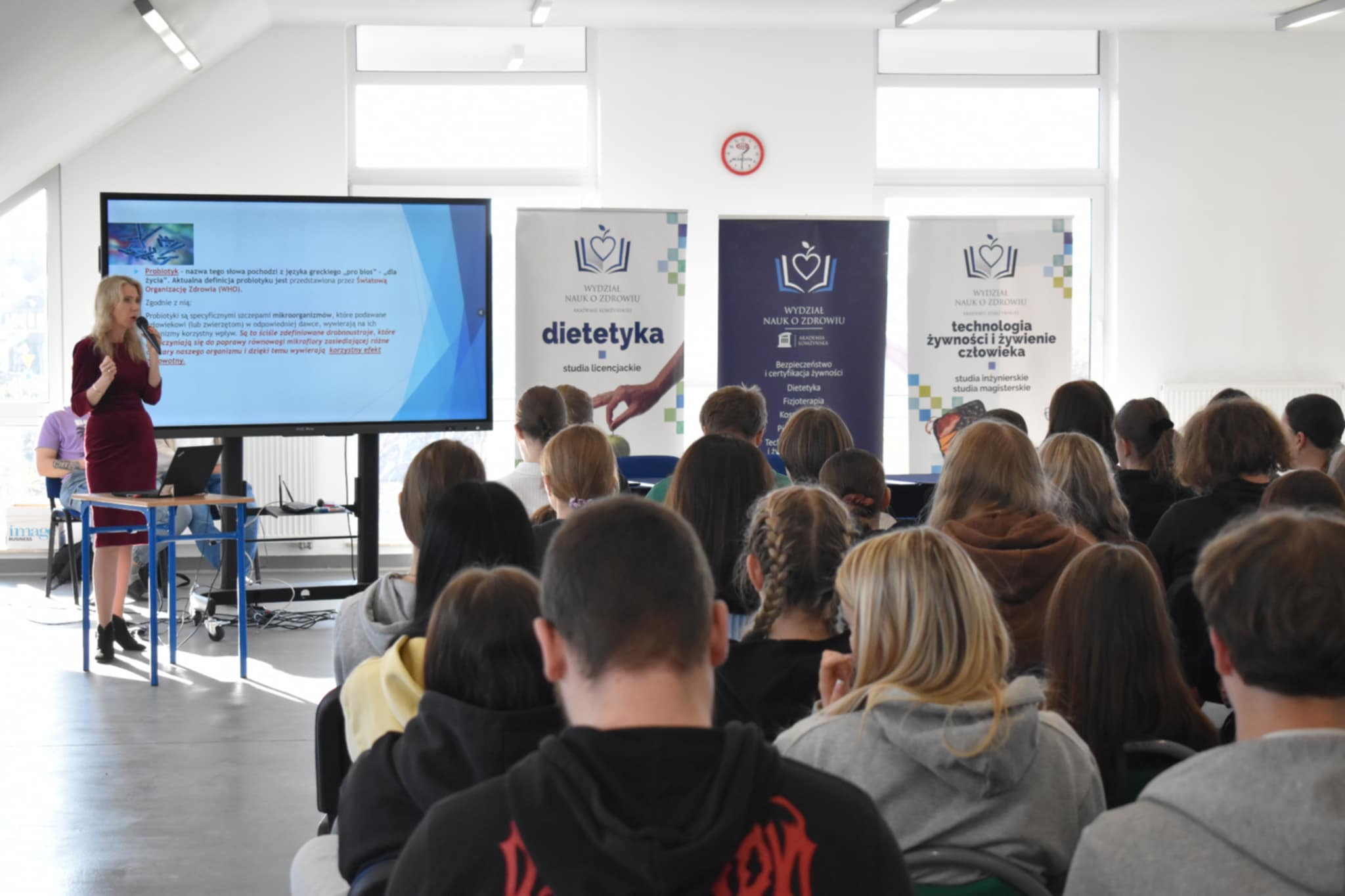 Zdjęcie przedstawia dużą grupę uczniów siedzących w dużej sali podczas wykładu o zdrowym stylu życia