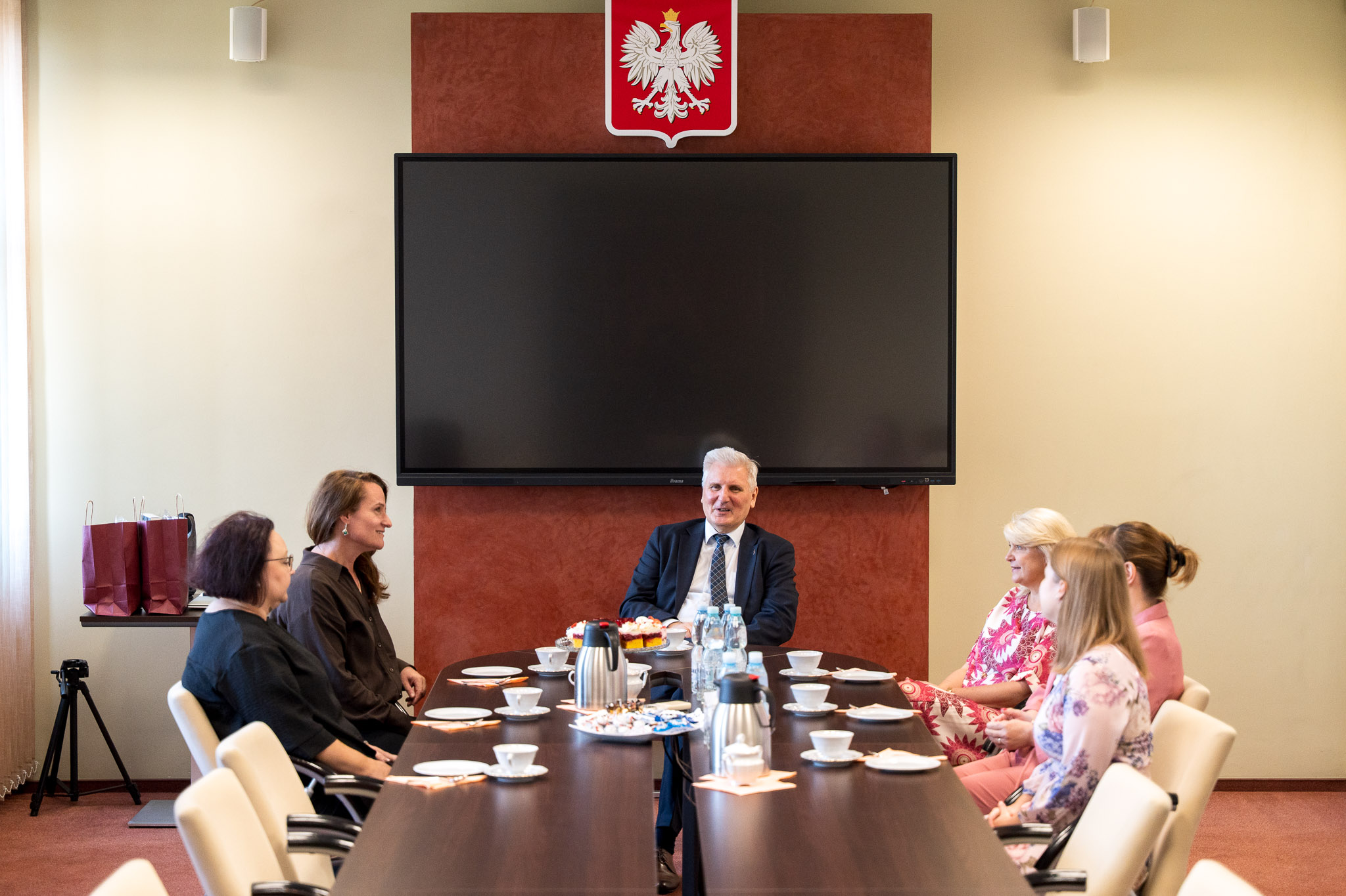 Zdjęcie przedstawia 6 osób siedzących przy stole
