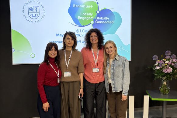 Grupa czterech uczestników International Staff Week Erasmus+ stojąca przed ekranem z prezentacją Lithuanian University of Health Sciences w Kownie (maj 2026).