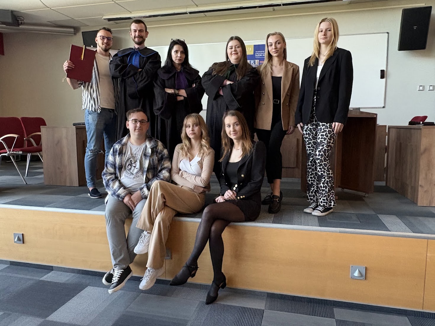 Studenci odgrywajacy symulację rozprawy sądowej wraz z opiekunem wydarzenia.
