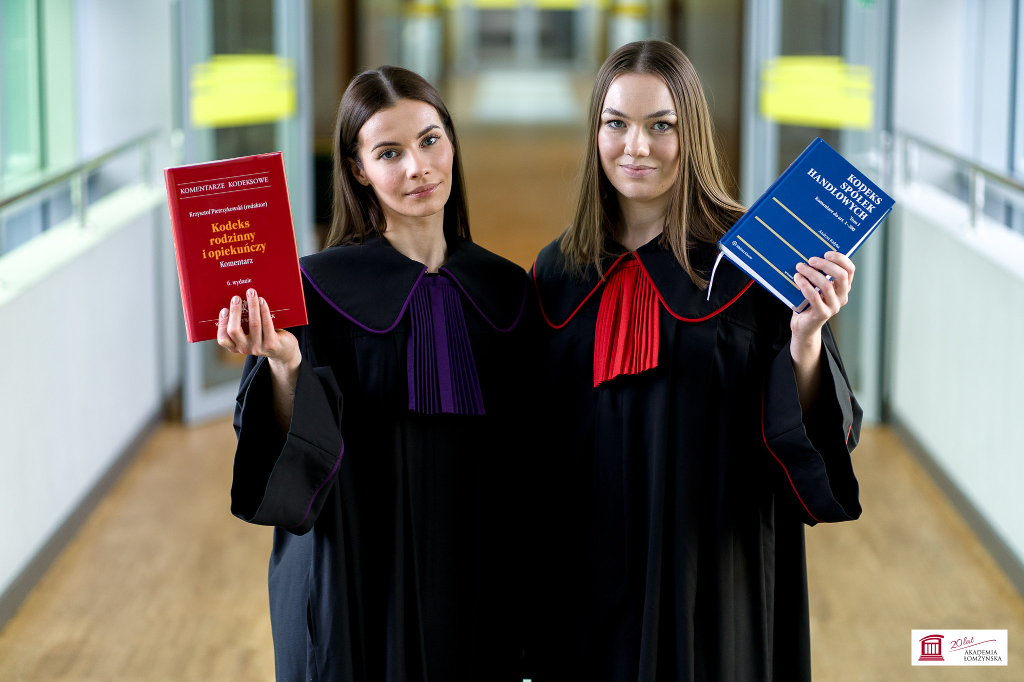 Dwie studentki w czarnych togach trzymają kodeksy